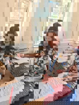 Caucasian womn sitting at a desk working. This women is Ava McAuley.